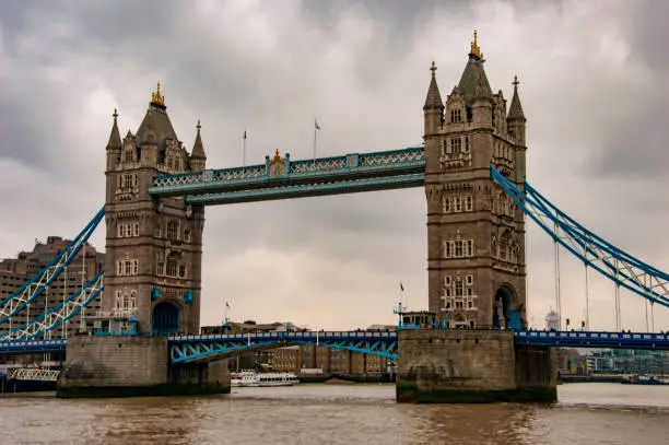 The river thames and tower bridge with cloudy sky and low light