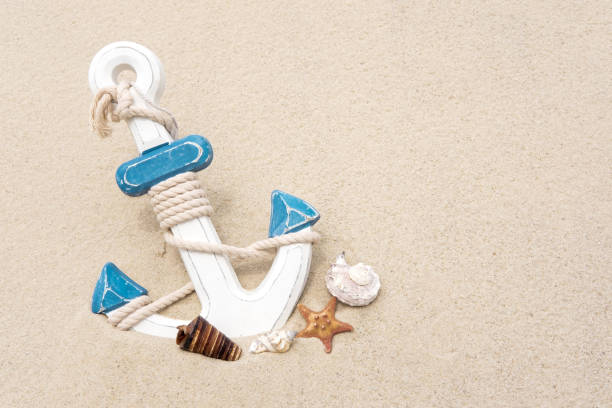 istock Nautical background with anchor. Anchor in the sand. Frame for a banner text from sand with an anchor and seashells 1148695627