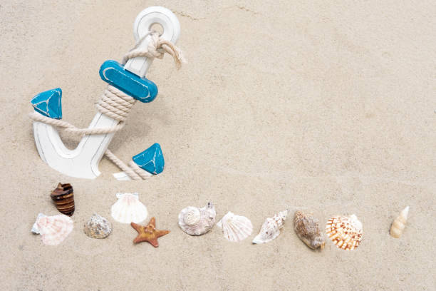 istock Nautical background with anchor. Anchor in the sand. Frame for a banner text from sand with an anchor. Sea background with anchor and seashells 1148696670
