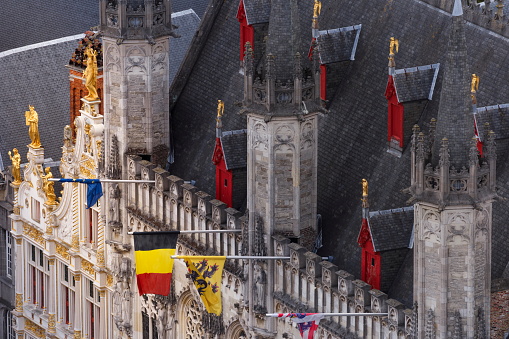 Above Bruges Burg square and City Hall with Belgian flag and Euro flags – Belgium