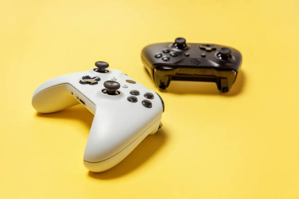istock White and black two joystick on yellow background. Computer gaming competition videogame control confrontation concept 1148701502