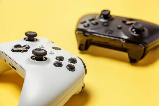 istock White and black two joystick on yellow background. Computer gaming competition videogame control confrontation concept 1148701513