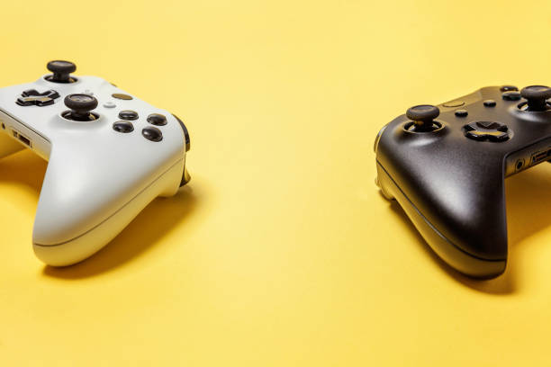 istock White and black two joystick on yellow background. Computer gaming competition videogame control confrontation concept 1148701542