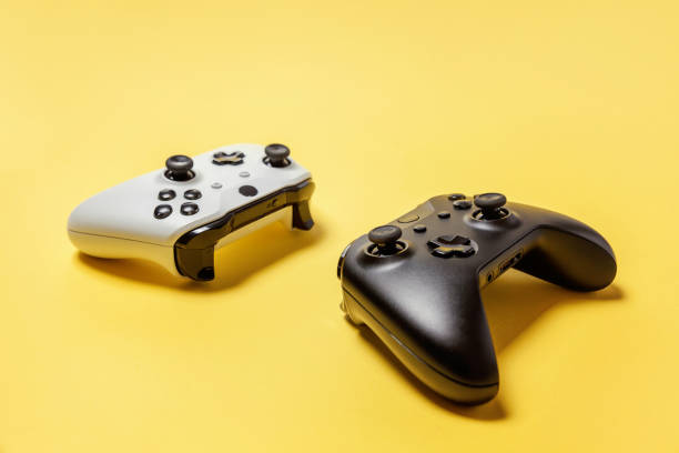 istock White and black two joystick on yellow background. Computer gaming competition videogame control confrontation concept 1148701586