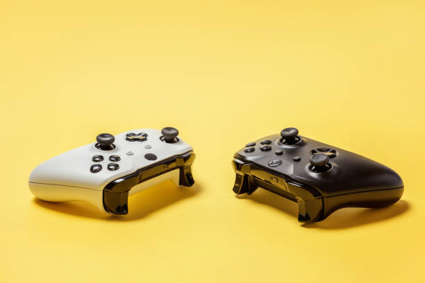 istock White and black two joystick on yellow background. Computer gaming competition videogame control confrontation concept 1148701605