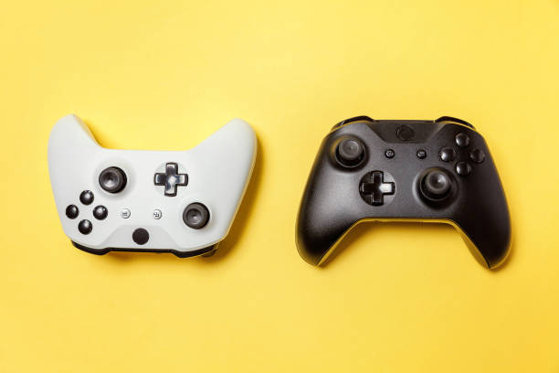 istock White and black two joystick on yellow background. Computer gaming competition videogame control confrontation concept 1148701617