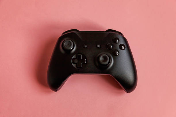 istock Black joystick on pink background. Computer gaming competition videogame control confrontation concept 1148702220