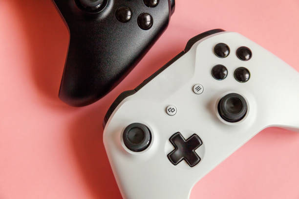 istock White and black two joystick on pink background. Computer gaming competition videogame control confrontation concept 1148702286