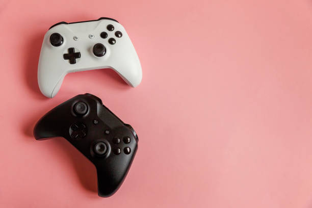 istock White and black two joystick on pink background. Computer gaming competition videogame control confrontation concept 1148702316