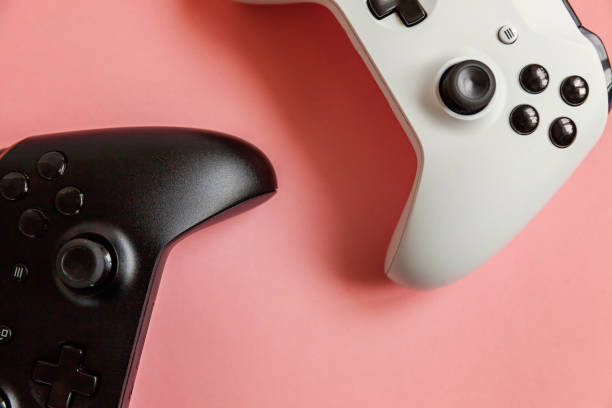 istock White and black two joystick on pink background. Computer gaming competition videogame control confrontation concept 1148702326