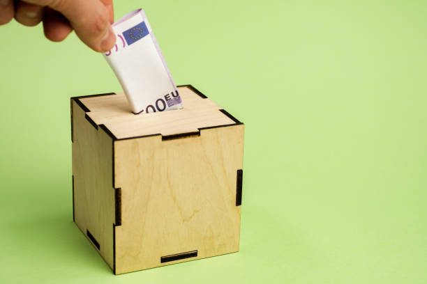 istock Hand depositing euro bill into moneybox 1148702366