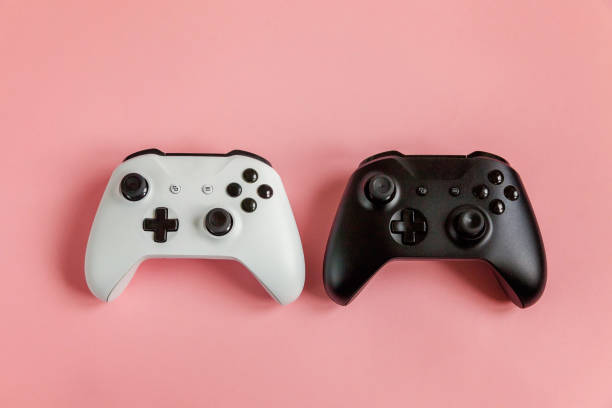 istock White and black two joystick on pink background. Computer gaming competition videogame control confrontation concept 1148702368