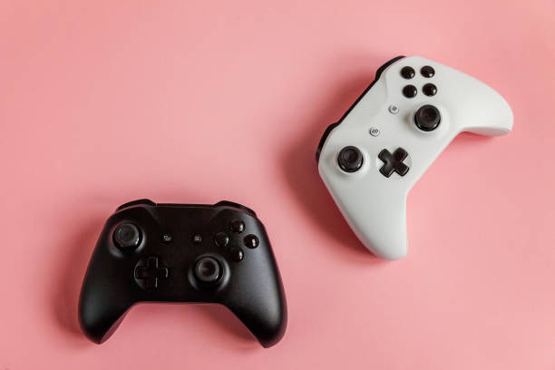 istock White and black two joystick on pink background. Computer gaming competition videogame control confrontation concept 1148702399