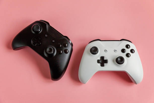 istock White and black two joystick on pink background. Computer gaming competition videogame control confrontation concept 1148702435