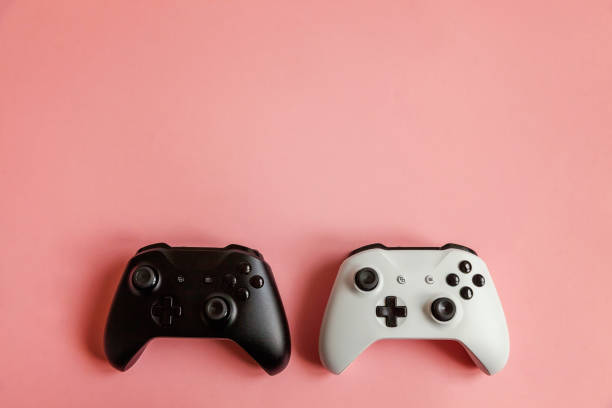 istock White and black two joystick on pink background. Computer gaming competition videogame control confrontation concept 1148704870