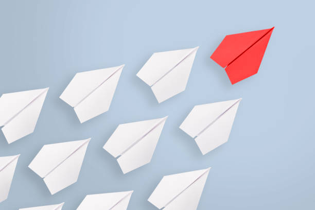 istock Leadership concepts with red paper airplane leading among white 1148705622