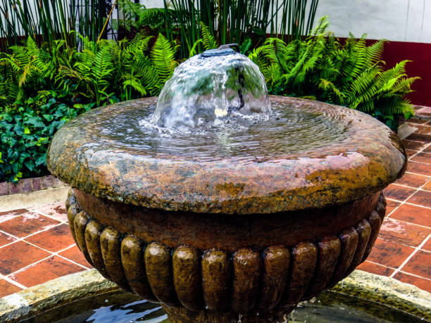 cima di antica fontana d'acqua con giardino sullo sfondo - fountain in garden foto e immagini stock