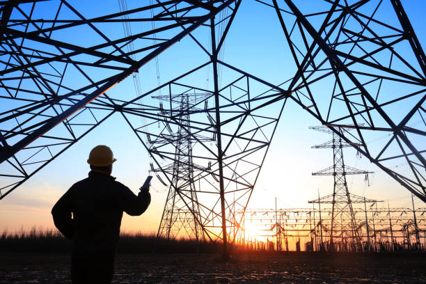 Electricity workers and pylon silhouette Electricity workers and pylon silhouette fuel and power generation photos stock pictures, royalty-free photos & images