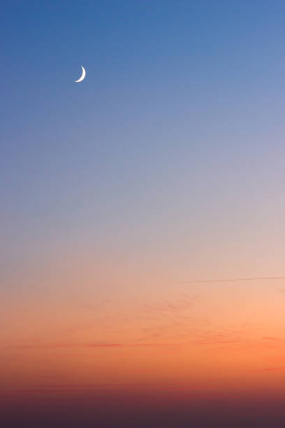 istock Beautiful summer sunset - dark blue sky with visible moon and orange horizon 1148713370