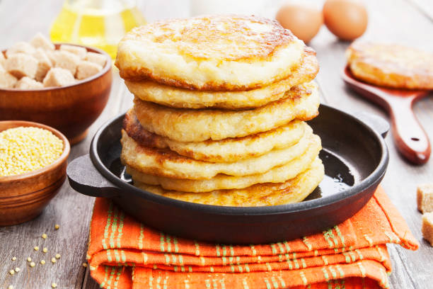 Millet pancakes in a frying pan stock photo
