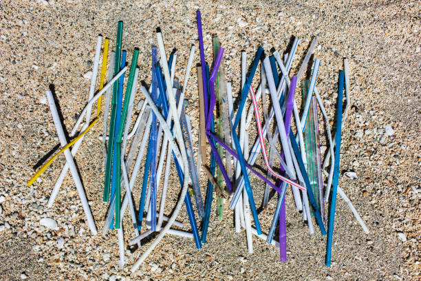istock Heap of different multicolor plastic straws collected on the beach on sand background 1148714234