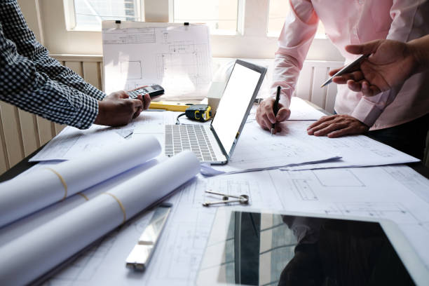 istock architect engineer team working on house blueprint of real estate project at workplace. construction & building concept 1148714452