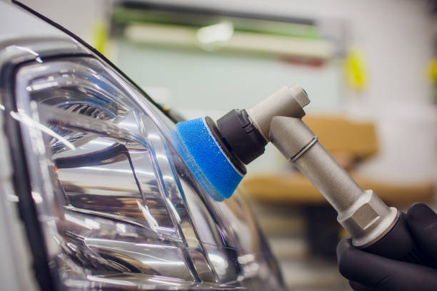 auto mechanic buffing and polishing car headlight