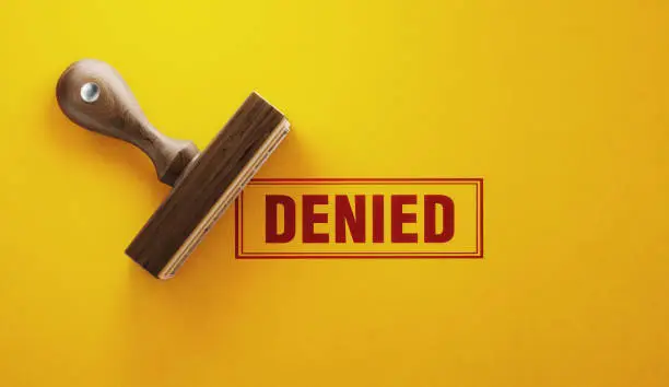 Photo of Wooden Denied Stamp On Yellow Background