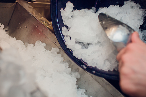 silver ice scoops in a large ice-filled bucket