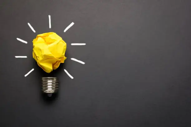 Photo of Great idea concept with crumpled yellow paper light bulb