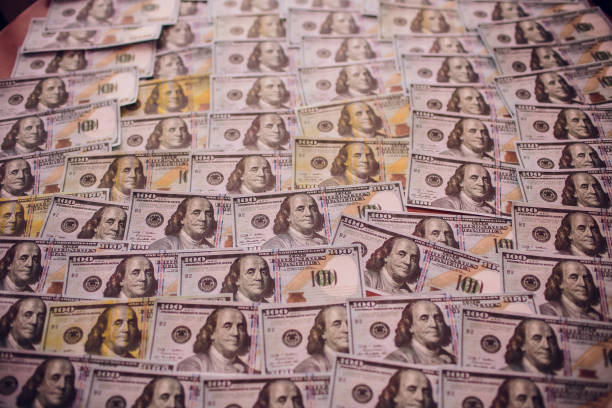 istock Hundreds of new Benjamin Franklin 100 dollar bills arranged randomly with the portrait facing uppermost in a closeup conceptual financial and monetary background 1148717425