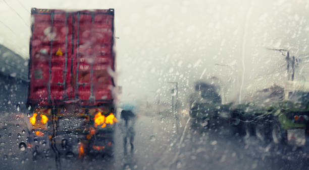 Blurry trucks ,view through the windshield of a car in the rain. stock photo