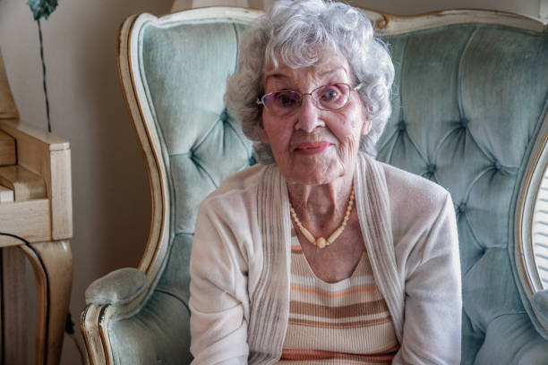 a smiling, confident 100-year old woman in her home - 80 year old imagens e fotografias de stock