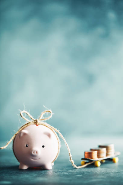 istock Little pink piggy bank pulling a skateboard with money 1148728526