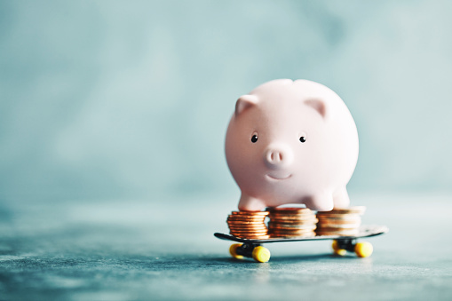 Little pink piggy riding on a skateboard with money