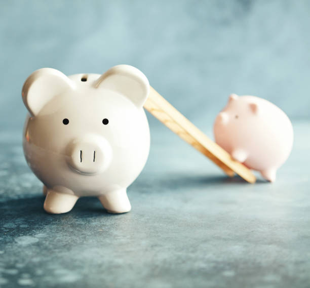 istock Piggy banks with ladder in blue setting 1148728587