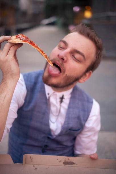 istock one young businessman eating pizza cut. 1148728666