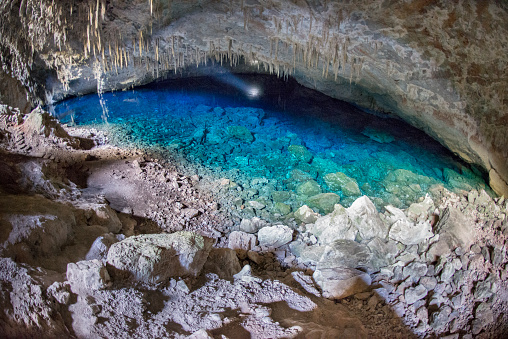 Gruta do Lago Azul natural monument in Bonito, Mato Grosso do Sul. Cave with water on a blue lake illuminated with a flashlight.