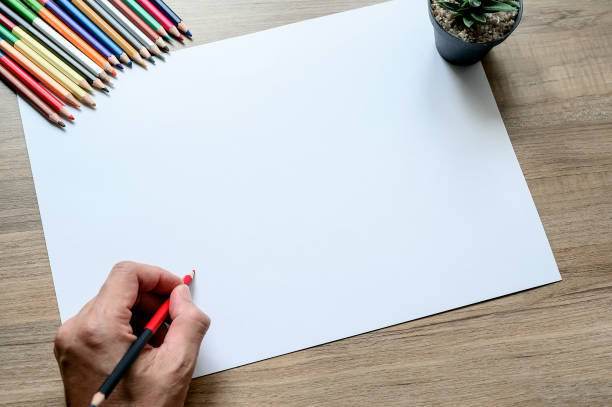 Blank white paper for sketch, hand drawn projects, mockup white paper on wooden table.