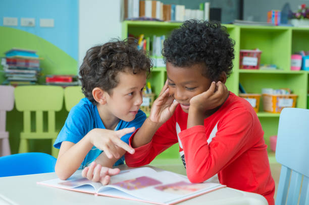 istock Two boy kid sit on table and coloring in book  in preschool library,Kindergarten school education concept 1148743594