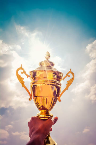 istock Holding up a gold trophy cup as a winner 1148746666