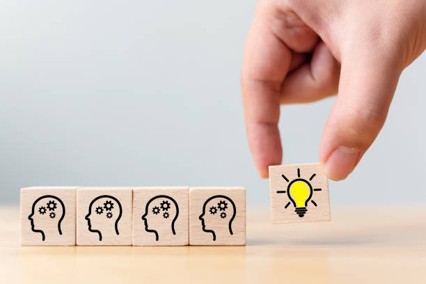 istock Concept creative idea and innovation. Hand picked wooden cube block with head human symbol and light bulb icon 1148751495