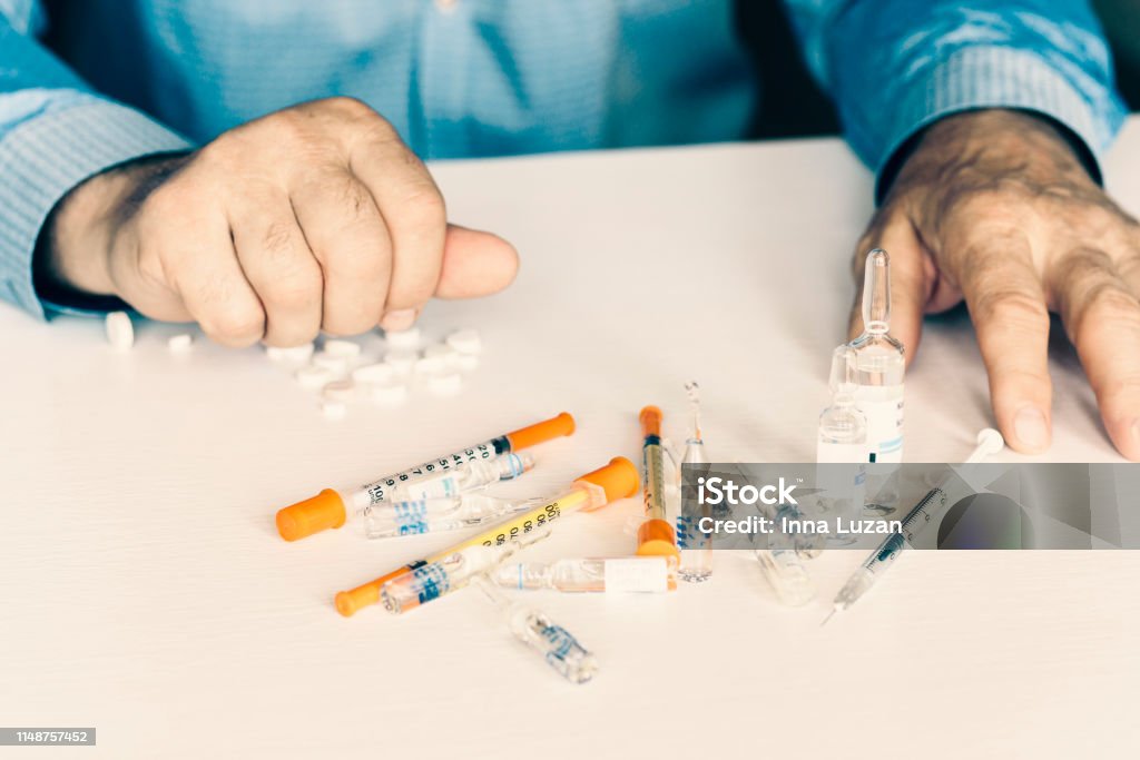 Medicine pills or capsules with man"u2019s hands on white background with copy space Acetylsalicylic Acid Stock Photo