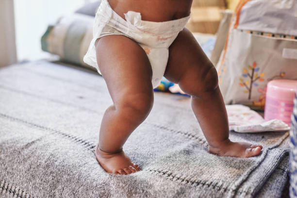 It's never too early to take those first steps Cropped shot of a baby learning to walk on the bed at home Diaper stock pictures, royalty-free photos & images