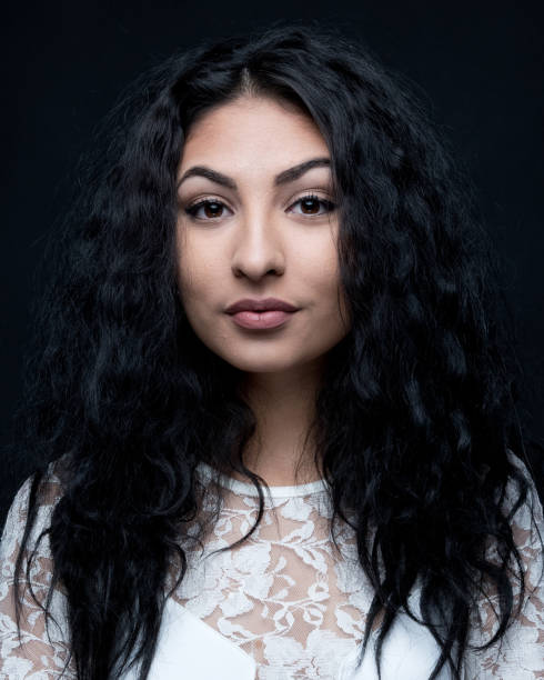 istock Good looking female with curly hair on black background 1148758088