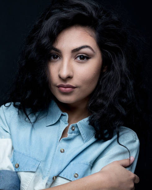 istock Good looking female with curly hair on black background 1148759191