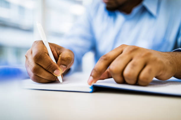 istock Close up of unrecognizable businessman taking notes in the office. 1148759818