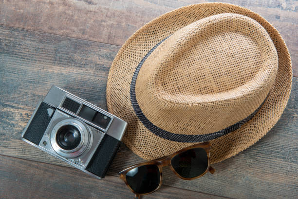 Summer hat and camera ready for the holidays on the  wooden background