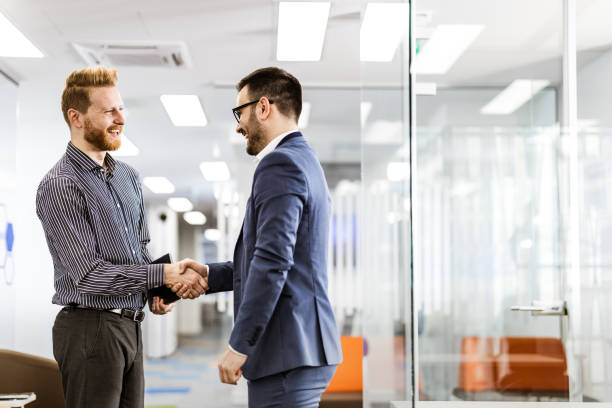 istock Happy businessmen talking while greeting each other in a hallway. 1148760425