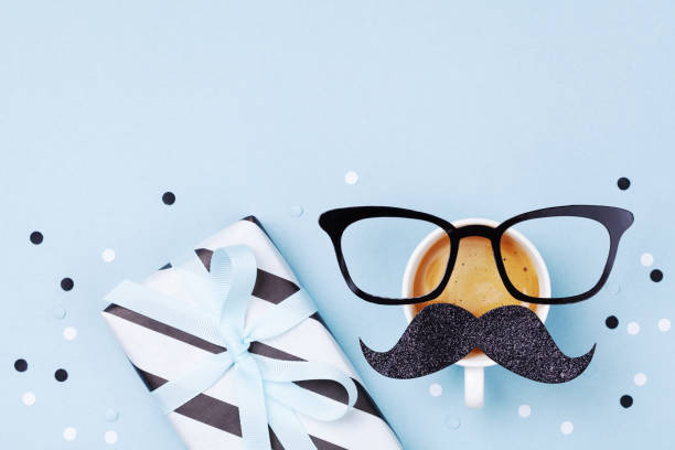 istock Creative breakfast on Happy Fathers Day with gift box and funny face from cup of coffee, eyeglasses and moustache. Flat lay. 1148761255